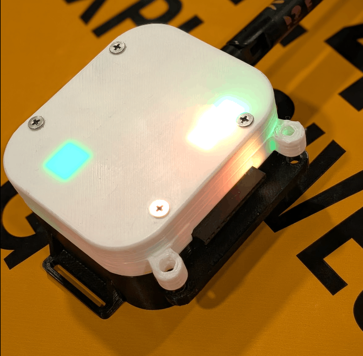Assembled receiver in its 3D-printed enclosure with multiple status LEDs lit through the case