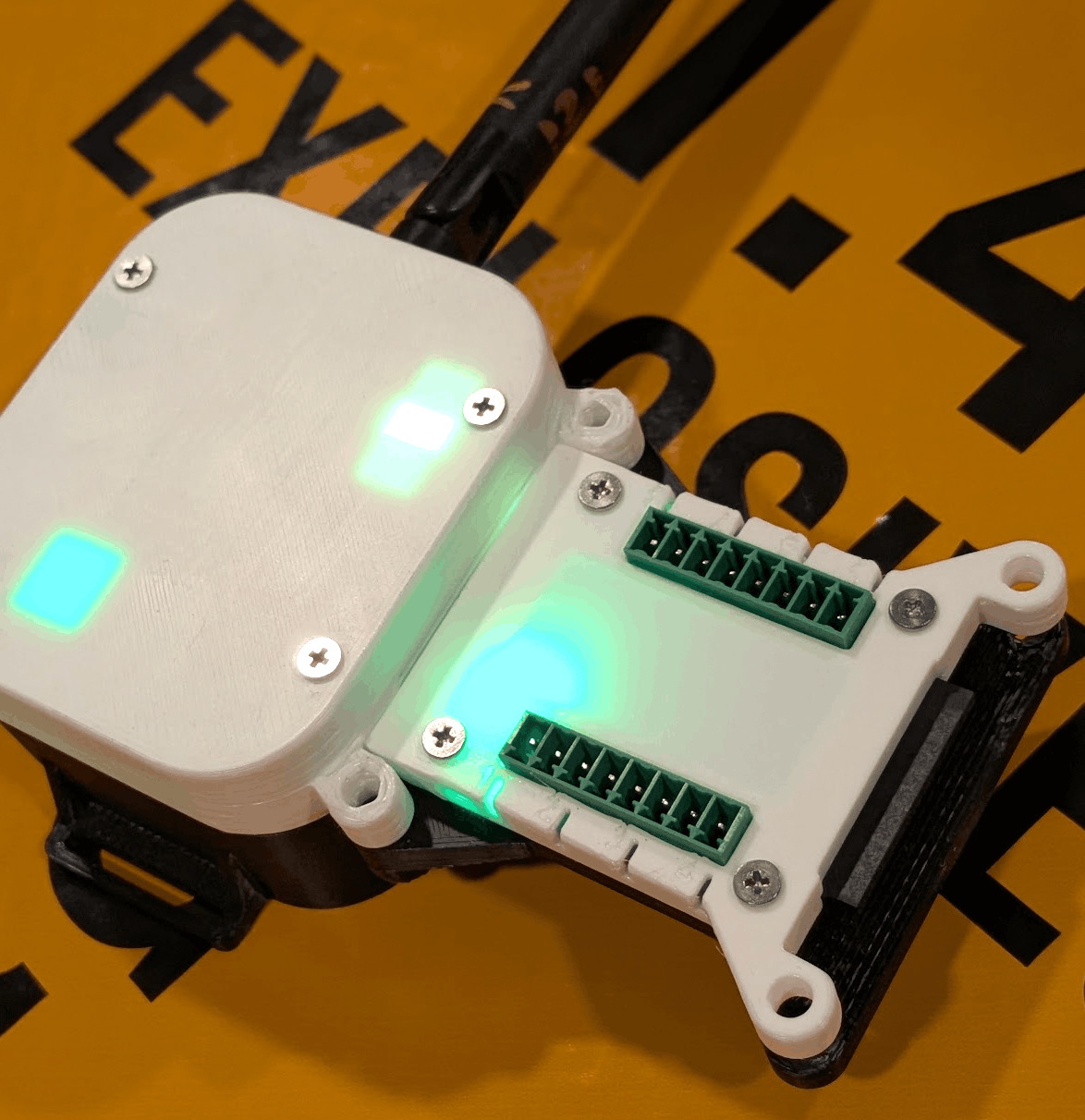 A receiver and a cue module mounted together, status LEDs lit on both